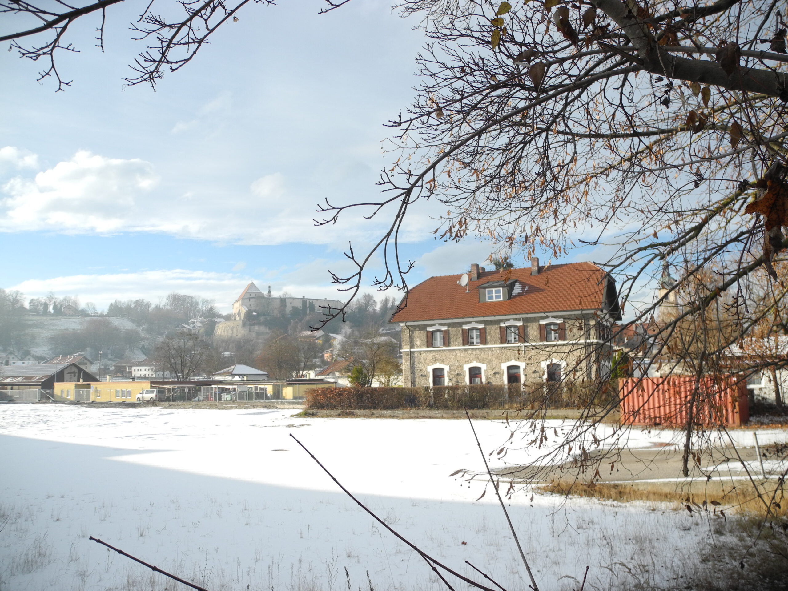 Verschneites Baufeld mit Blick auf Bahnhof und Burg